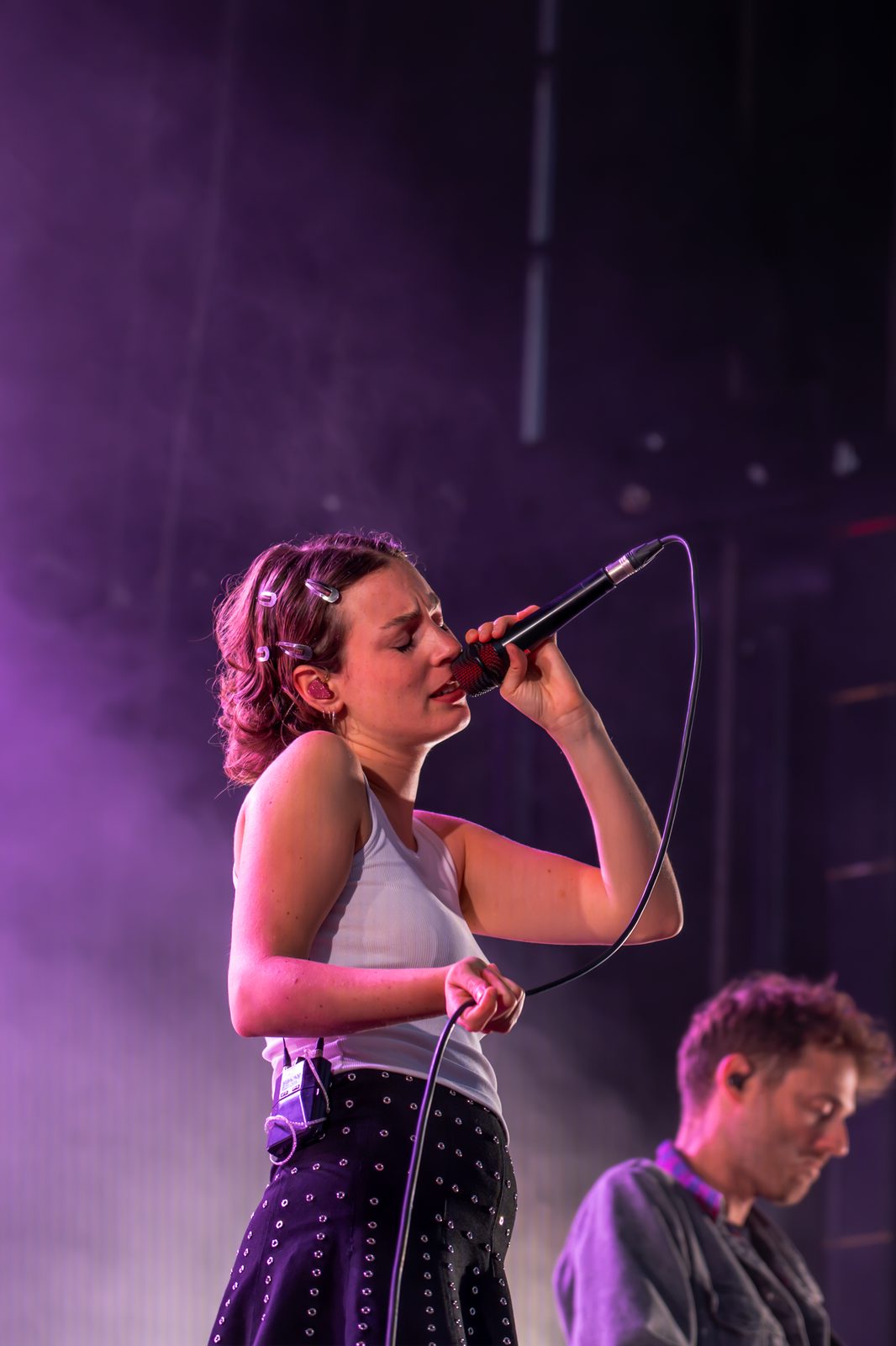 Chanteuse chantant avec intensité, musicien en arrière-plan