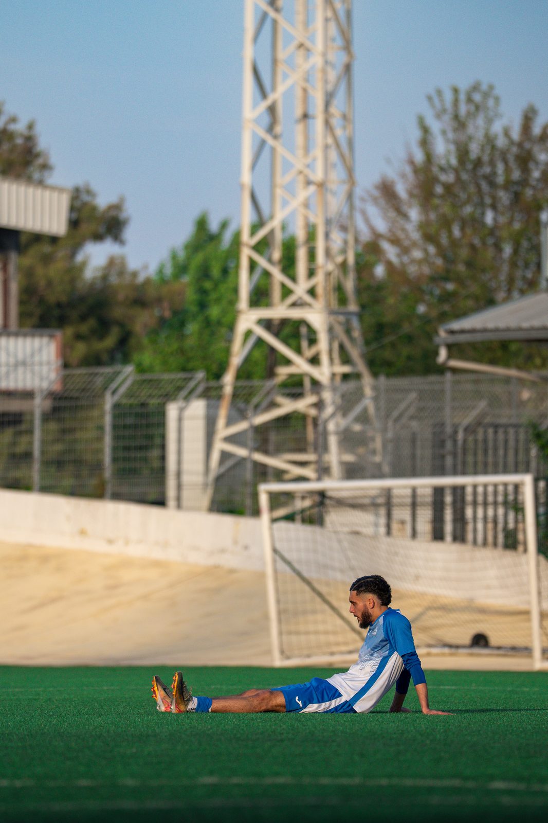 Joueur au sol en étirement devant les buts