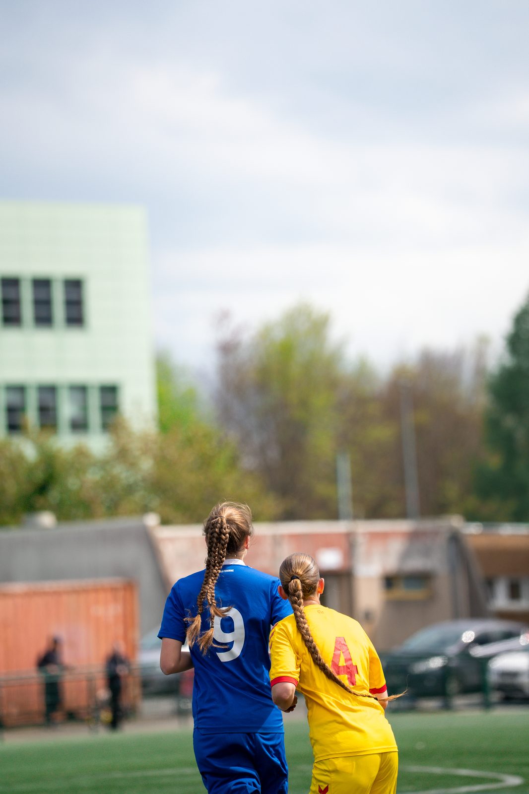 Deux joueuses de dos, maillots bleu et jaune